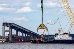 A US Coast Guard boat approaches clean-up operations at the Francis Scott Key Bridge as the main shipping channel prepares to fully reopen, in Baltimore, Maryland, June 10, 2024. 