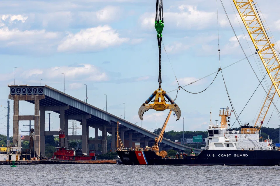 A US Coast Guard boat approaches clean-up operations at the Francis Scott Key Bridge as the main shipping channel prepares to fully reopen, in Baltimore, Maryland, June 10, 2024. 