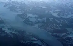 Glacial ice from the Greenland Ice Sheet flows around mountains into the ocean on the east coast of Greenland, July 21, 2022. At 2 deg C, the impact of climate change would be even greater, including irreversible loss to Earth’s ice sheets, mountain glaciers and snow, sea ice and permafrost.