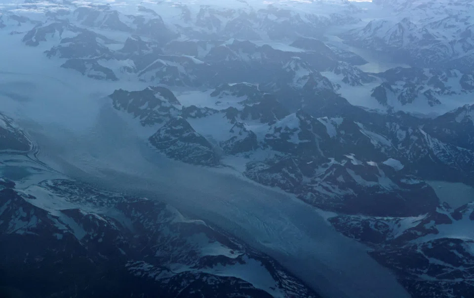 Glacial ice from the Greenland Ice Sheet flows around mountains into the ocean on the east coast of Greenland, July 21, 2022. At 2 deg C, the impact of climate change would be even greater, including irreversible loss to Earth’s ice sheets, mountain glaciers and snow, sea ice and permafrost.