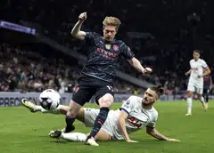Belgian playmaker Kevin De Bruyne (in black) being tackled by Romanian defender Radu Dragusin in an English Premier League match in May 2024.