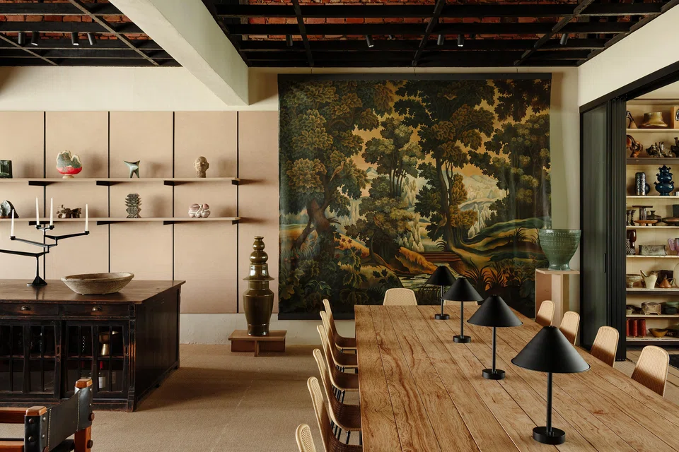 An oil painting by Asian-American painters Martin Fu and Tony Ho forms the backdrop for the dining table at This Humid House.