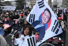 A supporter of South Korea President Yoon Suk Yeol waves a flag during a rally in Seoul, South Korea, Feb 25, 2025. Yoon’s policy to grow more closely aligned with Washington amid trade tensions between China and the US has increased South Korea’s reliance on the US market, leaving its businesses more vulnerable to potential tariff changes. 