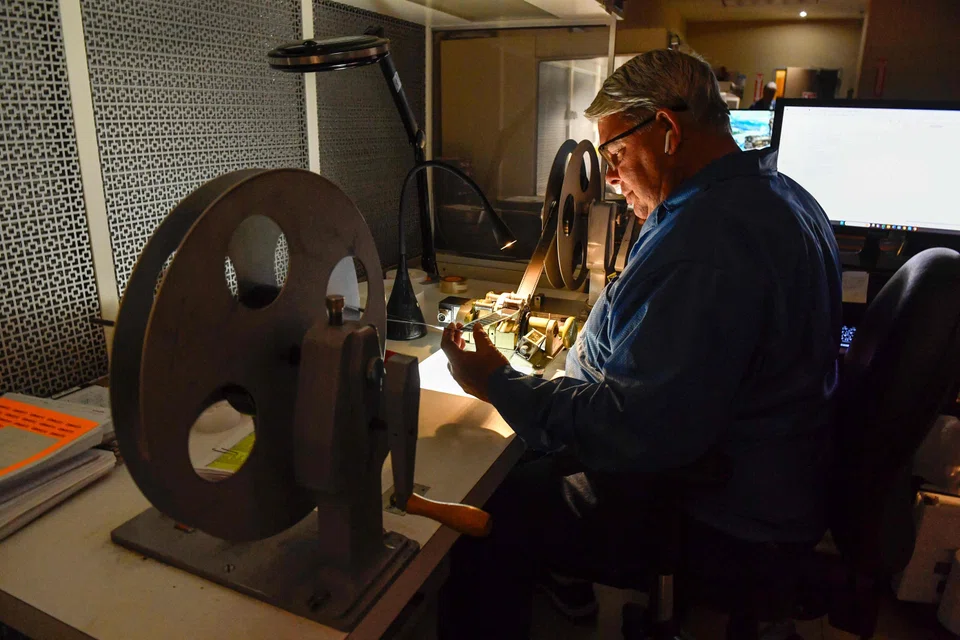 A specialist checking film. Old and new films all have to be stored – with the utmost care and under tight security.