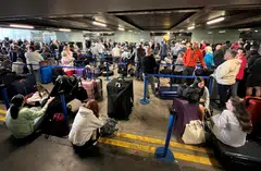 Passengers queueing outside Terminal 1; Manchester Airport says that it was working with airlines to reschedule cancelled flights in the coming days, adding that flights scheduled for Monday would be unaffected.