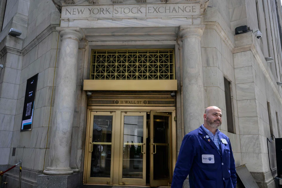 A trader walks out of the New York Stock Exchange on Wall Street in New York. Some Wall Street firms are revising their profit projections for multiple S&P 500 industry groups, based on the adoption of AI.