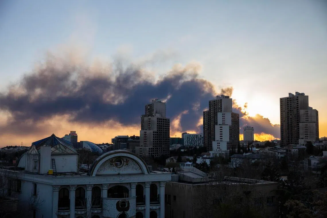 The sun sets as a cloud of smoke from airstrikes blankets the sky in Teheran, Iran, March 3, 2026. 