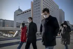 People walking past the Bank of China headquarters in Beijing, on Dec 22, 2022. In a recent interview, the central bank said it was relaxing the oversight of technology companies.   