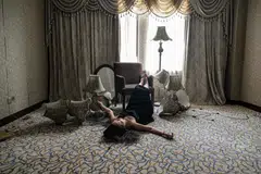 Model Mao Yi posing for pictures as she lies on the ground at a room inside an abandoned hotel in Shanghai.  
