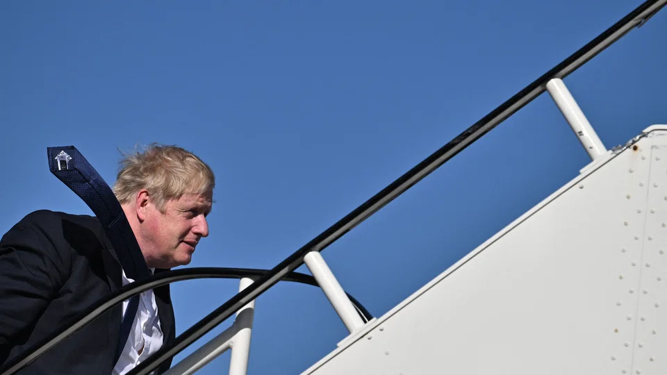 Britain's Prime Minister Boris Johnson boards a plane at Stansted Airport, outside London, on April 20, 2022 for a visit to India. 