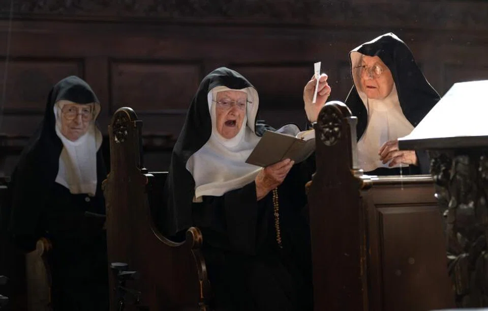 Sisters Rita (R), 81, Regina (L), 86, and Bernadette (C), 88, celebrate a mass with over a dozen of supporters and former students, at the convent chapel of the Goldenstein castle.