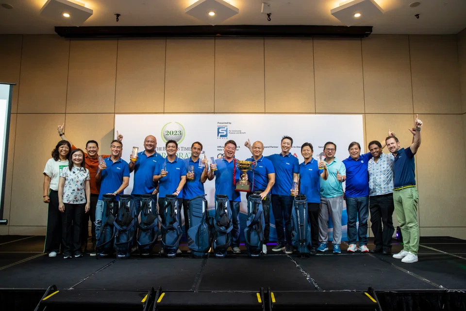 Winners Team Boss (in blue shirts, from left): John Lim, Chris Taw, Shaun Tay, Steven Lam, Terence Yong, William Tay, Ben Fones and Kelvin Kwok with the trophy. Joining them were BT editor Chen Huifen (second from left) and Singapore Pools CEO Lam Chee Weng (fourth from right).