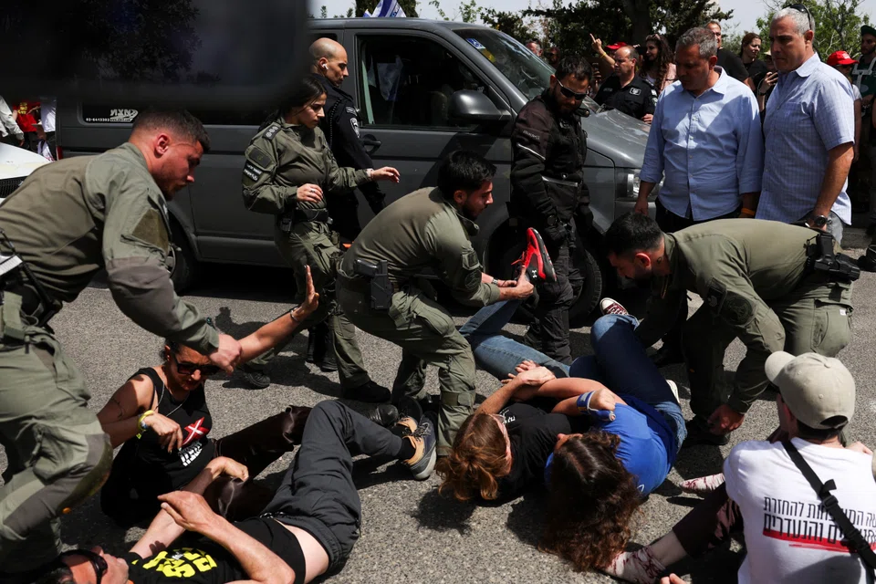 Members of security forces remove protesters, as demonstrators try to block the entrance to the Knesset. They are protesting against moves by the  government to fire the Attorney General and top security agency chief, as well as to demand the release of all hostages.