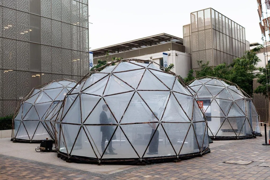 Pollution pods, geodesic domes simulating air pollution levels from Beijing, London and New Delhi, at the COP28 climate conferencein Dubai. Investors are watching for opportunities such as upgrades to power grids and agreements on reduction of methane emissions which will impact industries.  