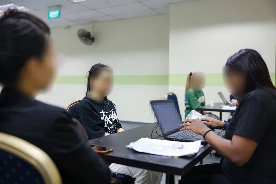 A woman (centre) arrested for suspected involvement in illegal employment on Sept 23, 2024.