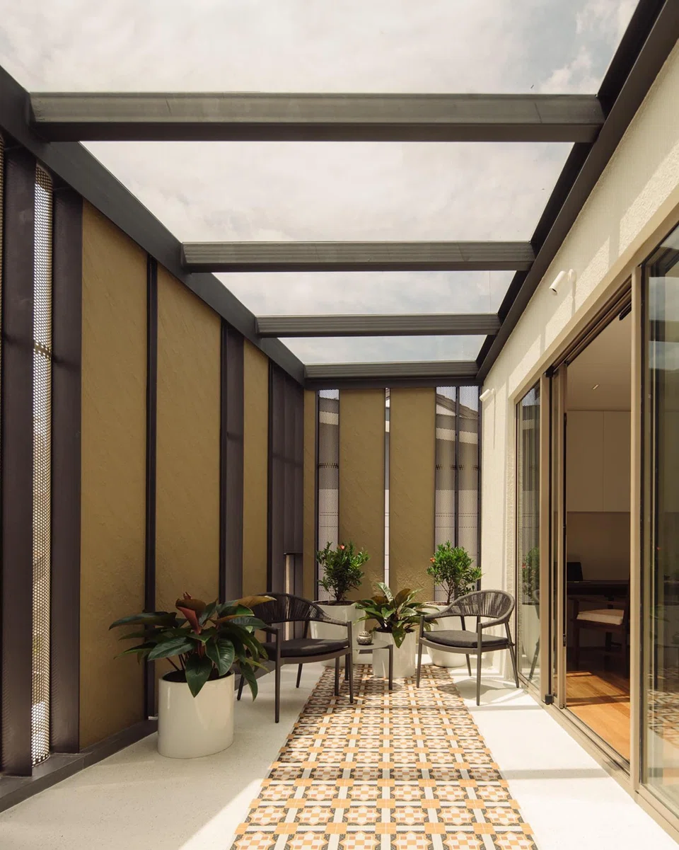 The master bedroom in the attic enjoys a terrace that is given privacy with the facade screen. 