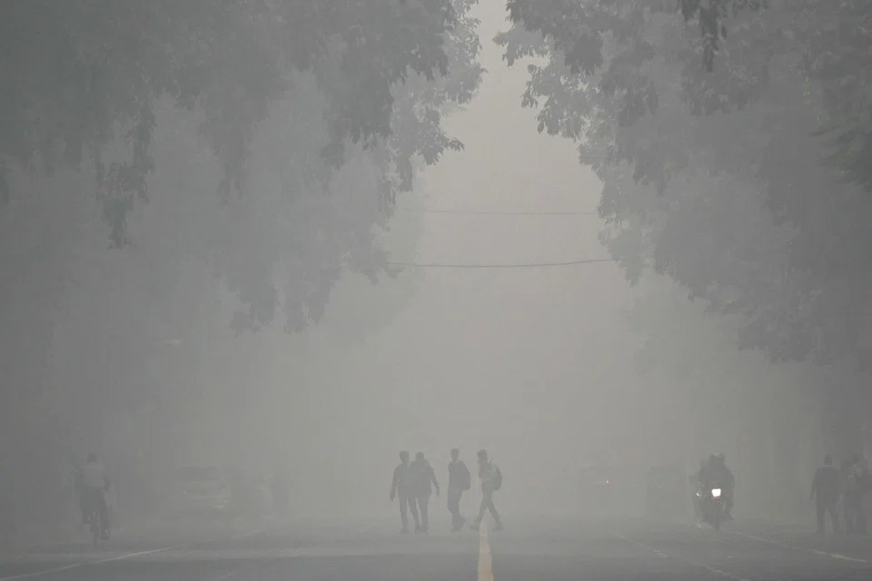 Pedestrians walk across a street on a cold smoggy morning in New Delhi, India, Nov 18, 2024. New Delhi and the surrounding metropolitan area, home to more than 30 million people, consistently tops world rankings for air pollution in winter.
