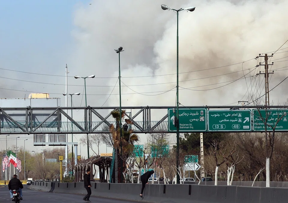 People run for safety as smoke rises after an airstrike in central Teheran on Mar 5. 
