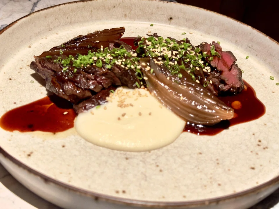 Wagyu hanger steak served with braised onion and potato puree.