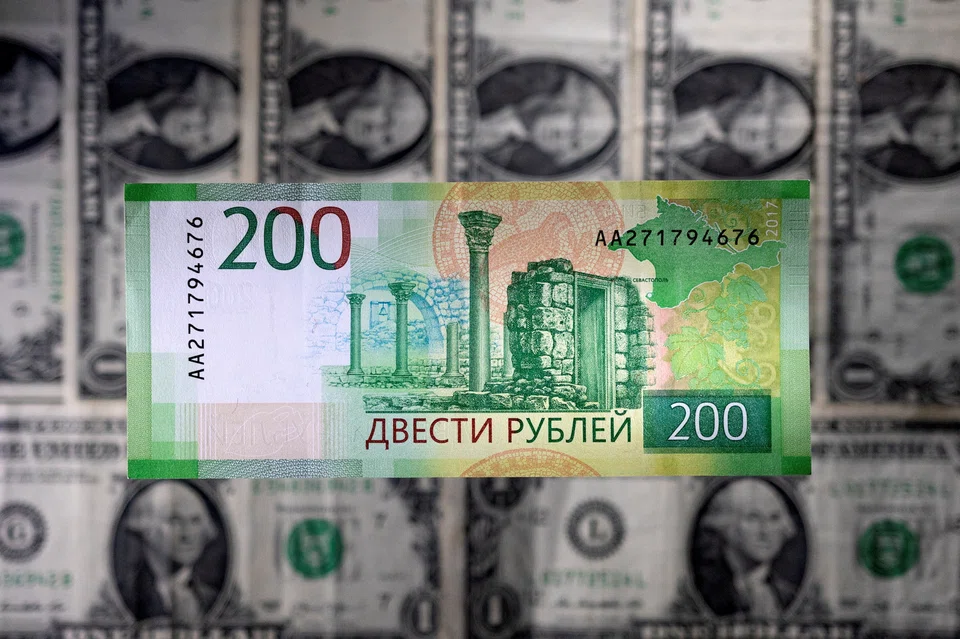 FILE PHOTO: A Russian rouble banknote is seen placed on U.S. dollar banknotes in this illustration taken March 1, 2022. REUTERS/Dado Ruvic/Illustration/File Photo