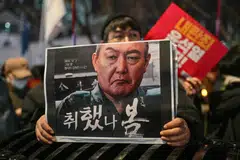 A protester holds a poster with an image of South Korea President Yoon Suk Yeol calling for his ouster in Seoul, South Korea, Dec 5, 2024. 
