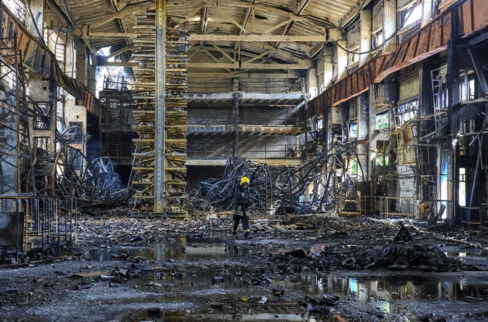 Ukrainian firefighters and rescuers work at the site of a damaged storage facility of a private factory following an overnight attack in Vasyshcheve, near Kharkiv, Ukraine, May 26, 2025.