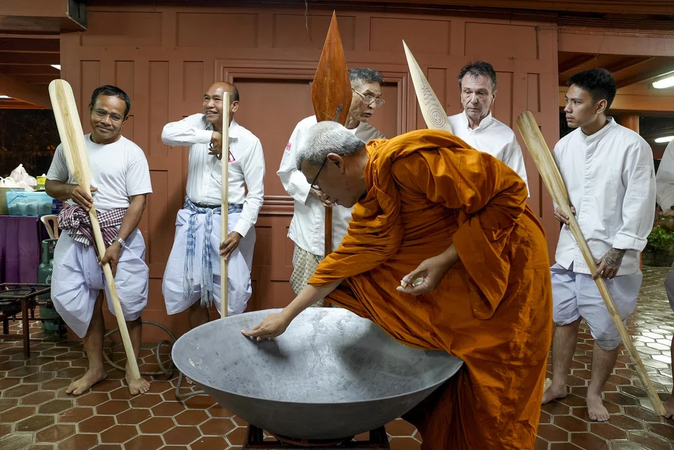 David Thompson, second from right, joins other chefs in making a rice offering.
