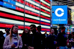 FILE — Coinbase employees gather in Times Square to see the launch of the company’s initial public offering displayed on the Nasdaq tower, April 14, 2021. Crypto companies are laying off staff, freezing withdrawals and trying to stem losses, raising questions about the health of the ecosystem. (Gabby Jones/The New York Times)