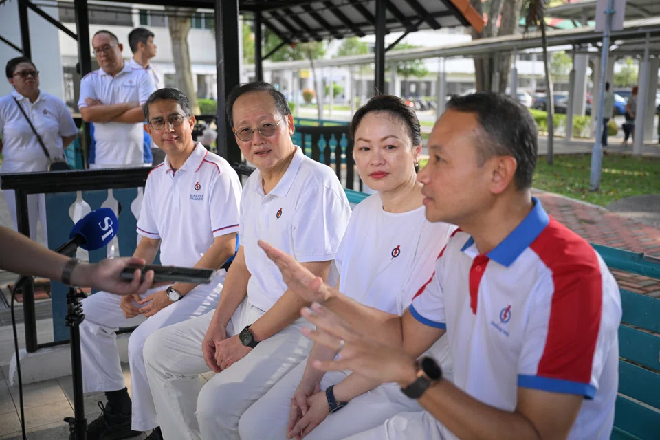Minister of State for Home Affairs and for National Development Muhammad Faishal Ibrahim, Manpower Minister and Marine Parade GRC MP Tan See Leng, business development director Diana Pang and South East District Mayor Mohd Fahmi Aliman speaking to ST near Eunos Crescent Market and Food Centre on March 30.