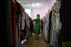 This photo taken on November 14, 2024 shows plus-size clothing brand owner and influencer Amanda Yao inspecting clothes in her office in Guangzhou, in Chinas southern Guangdong province. Surrounded by racks of colourful dresses and blazers in China's manufacturing hub of Guangzhou, plus-size clothing brand owner and influencer Amanda Yao is on a mission to promote body positivity. (Photo by GREG BAKER / AFP) / To go with AFP story China-lifestyle-women-clothing, FOCUS by Jing Xuan TENG