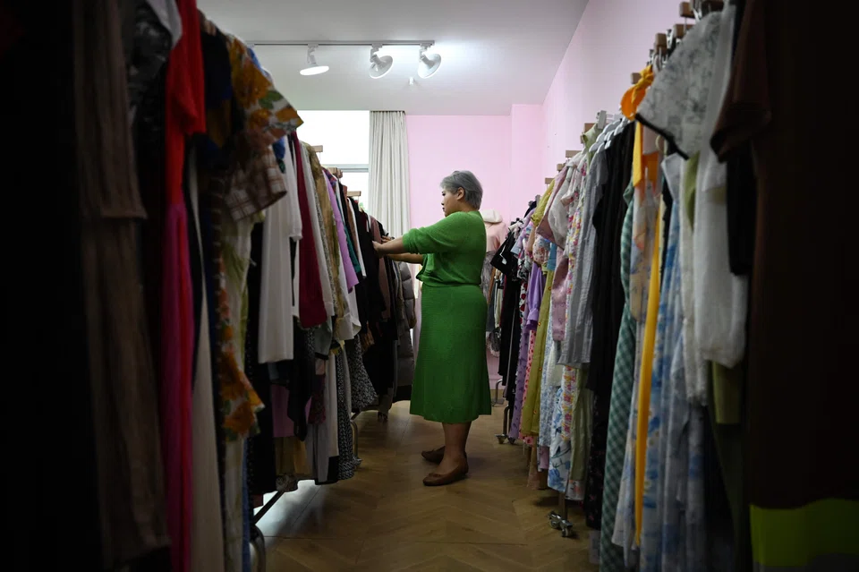 This photo taken on November 14, 2024 shows plus-size clothing brand owner and influencer Amanda Yao inspecting clothes in her office in Guangzhou, in Chinas southern Guangdong province. Surrounded by racks of colourful dresses and blazers in China's manufacturing hub of Guangzhou, plus-size clothing brand owner and influencer Amanda Yao is on a mission to promote body positivity. (Photo by GREG BAKER / AFP) / To go with AFP story China-lifestyle-women-clothing, FOCUS by Jing Xuan TENG