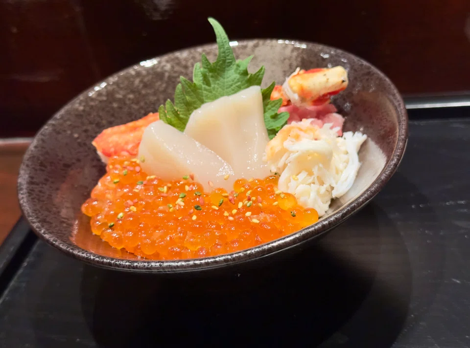 Chirashi sushi features uni, scallop and crab leg.