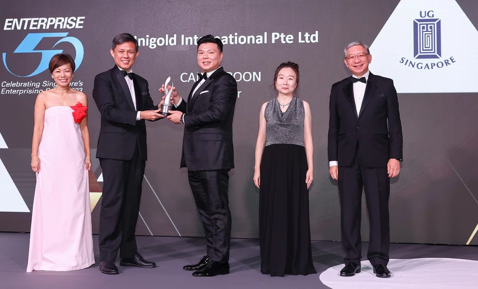 Minister Chan presenting the E50 Awards trophy to top winner Calvin Poon, director, Unigold International. Accompanying them (from left) are: Lee Sze Yeng, managing partner, KPMG in Singapore; Chen Huifen, editor, The Business Times and Linus Goh, head, global commercial banking, OCBC.