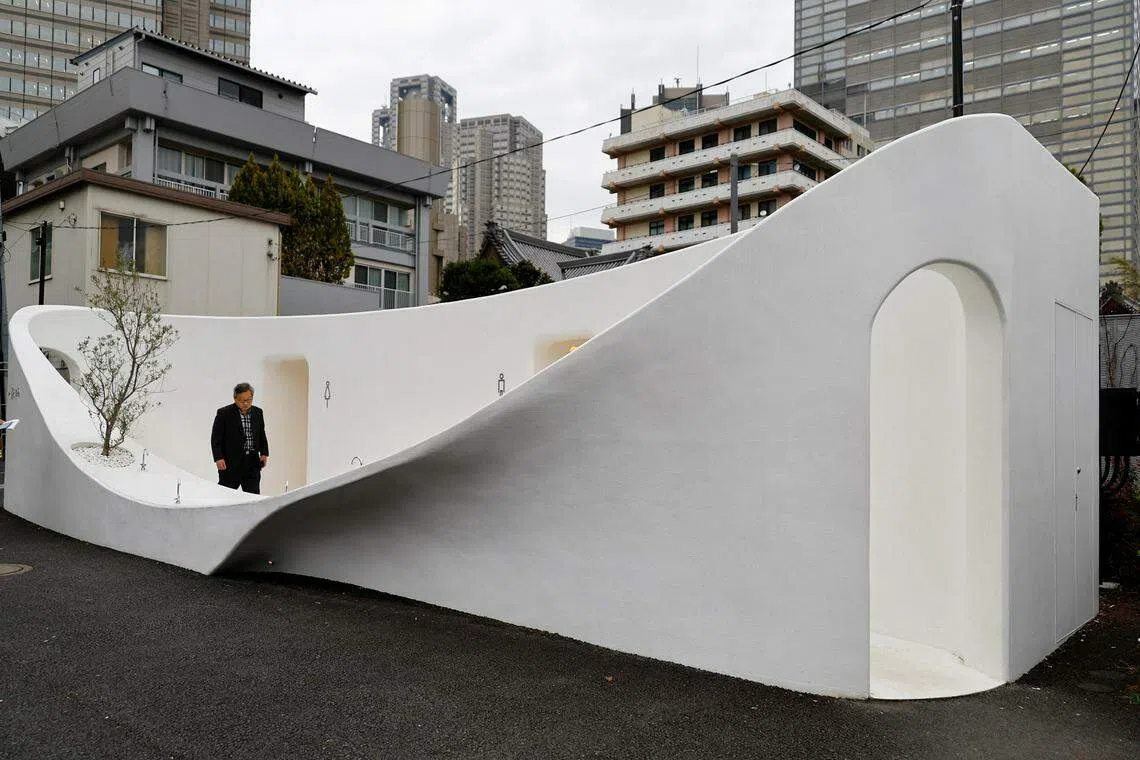 A participant looks around a public toilet which was redesigned as part of a project to transform public toilets into restrooms that can be used comfortably by everyone during a Tokyo Toilet Shuttle Tour at Shibuya ward in Tokyo.