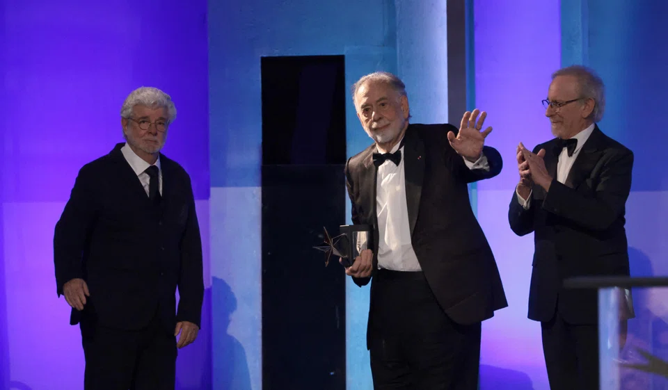 Francis Ford Coppola (centre) gestures on the stage after receiving the 50th AFI Life Achievement Award from George Lucas (left) and Steven Spielberg (right) at Dolby Theatre in Los Angeles on Apr 26.