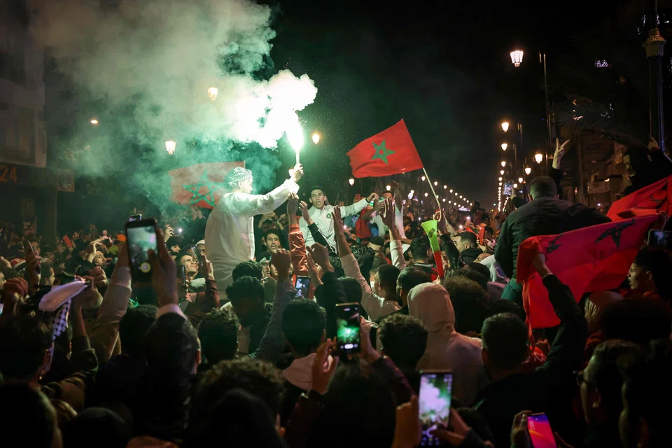 Moroccans celebrate their team's victory after the match between Morocco and Spain in Rabat, Morocco on Dec 6, 2022.