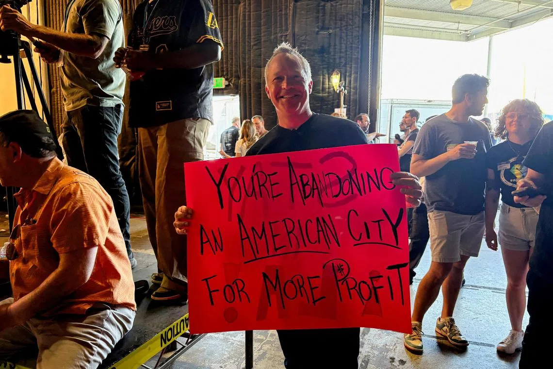 Production accountant Will Morris holds a sign at a "Stay in LA" rally in Sun Valley, California, April 6, 2025.