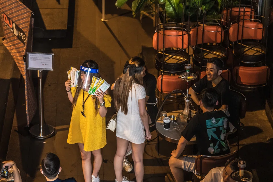 A customer holds packs of Covid-19 rapid antigen tests at a bar in Hong Kong's Lan Kwai Fong nightlife district. Hong Kong's bar and nightclub owners were caught off-guard when government officials announced that their patrons would have to show proof of a negative Covid-19 test in order to enter, starting Jun 16.   