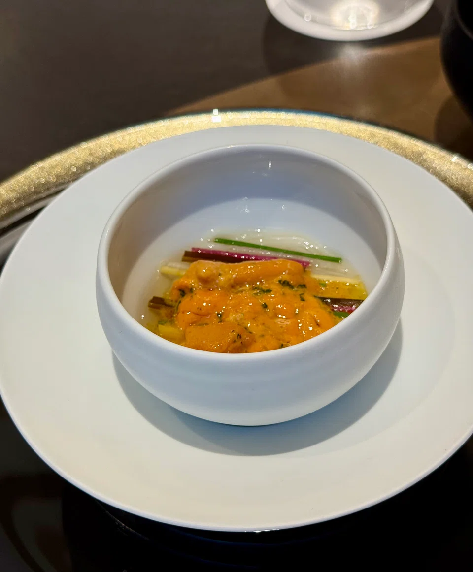 Cold uni somen is decorated with julienned multicoloured radish and chives.