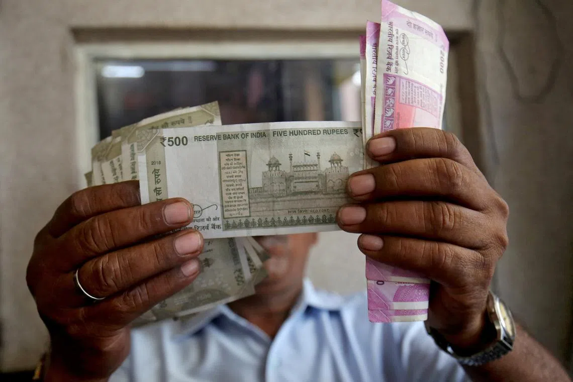 A cashier checks Indian rupee notes inside a room at a fuel station in Ahmedabad, India. Earlier this year, India overtook the UK to become the world's fifth-largest economy.