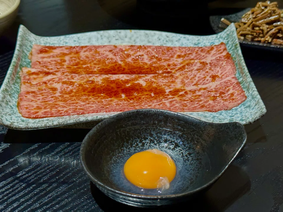 A slice of chuck flap is lightly grilled and eaten with raw egg yolk.
