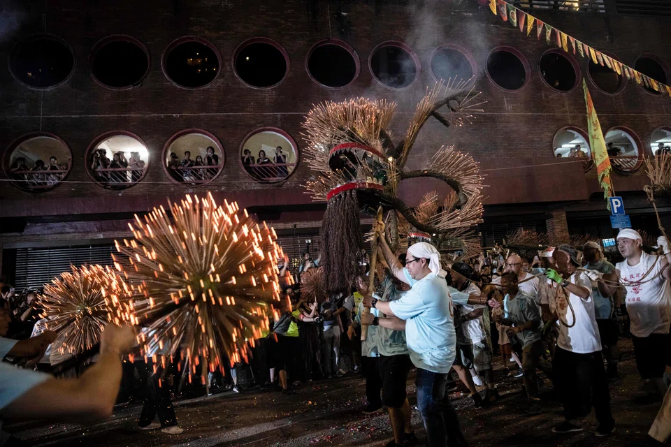 The dragon is hoisted by hundreds of volunteers who dance and bound along the streets of the Tai Hang neighbourhood in a raucous parade.