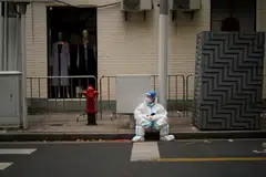 A worker in protective suit in Shanghai takes a break during the city's lockdown.
 