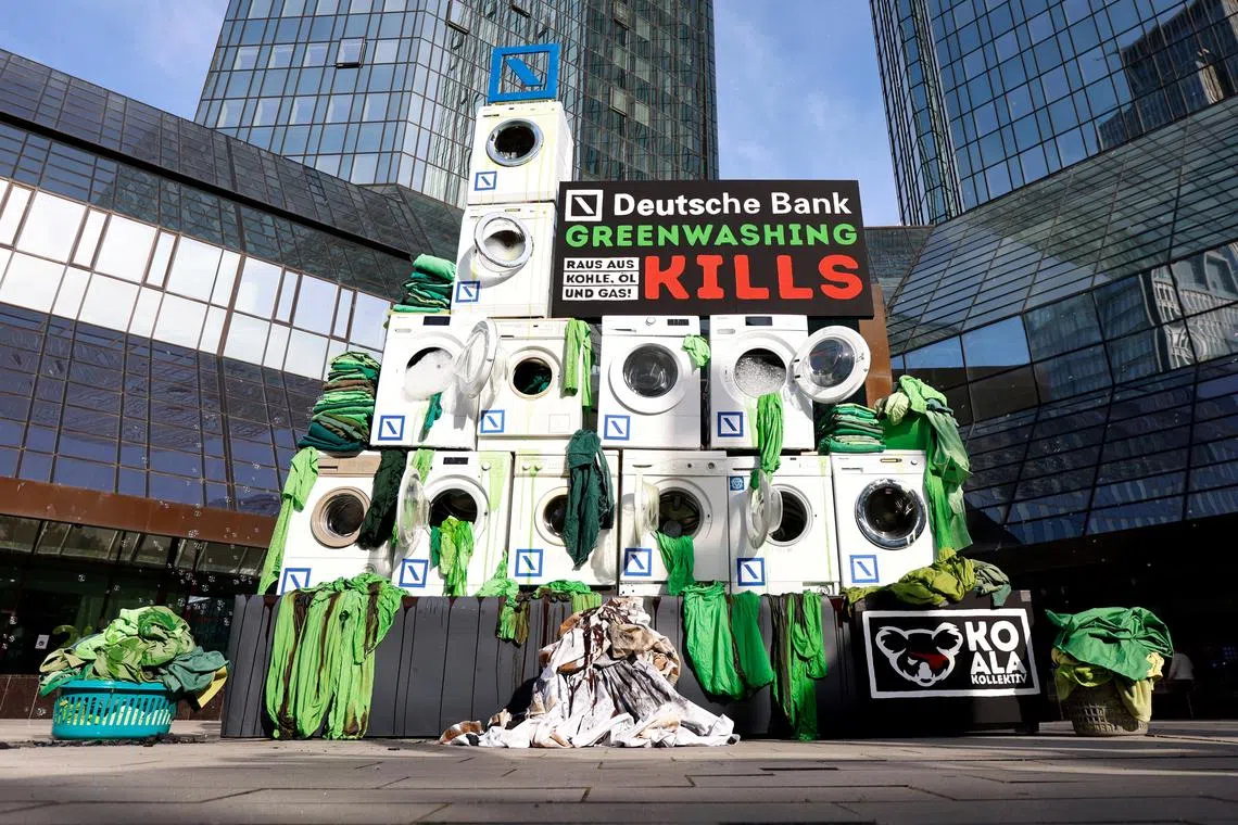 Activists stack washing machines in front of the Deutsche Bank headquarters to protest against greenwashing during the bank's annual shareholders meeting in Frankfurt, Germany, May 19, 2022.     