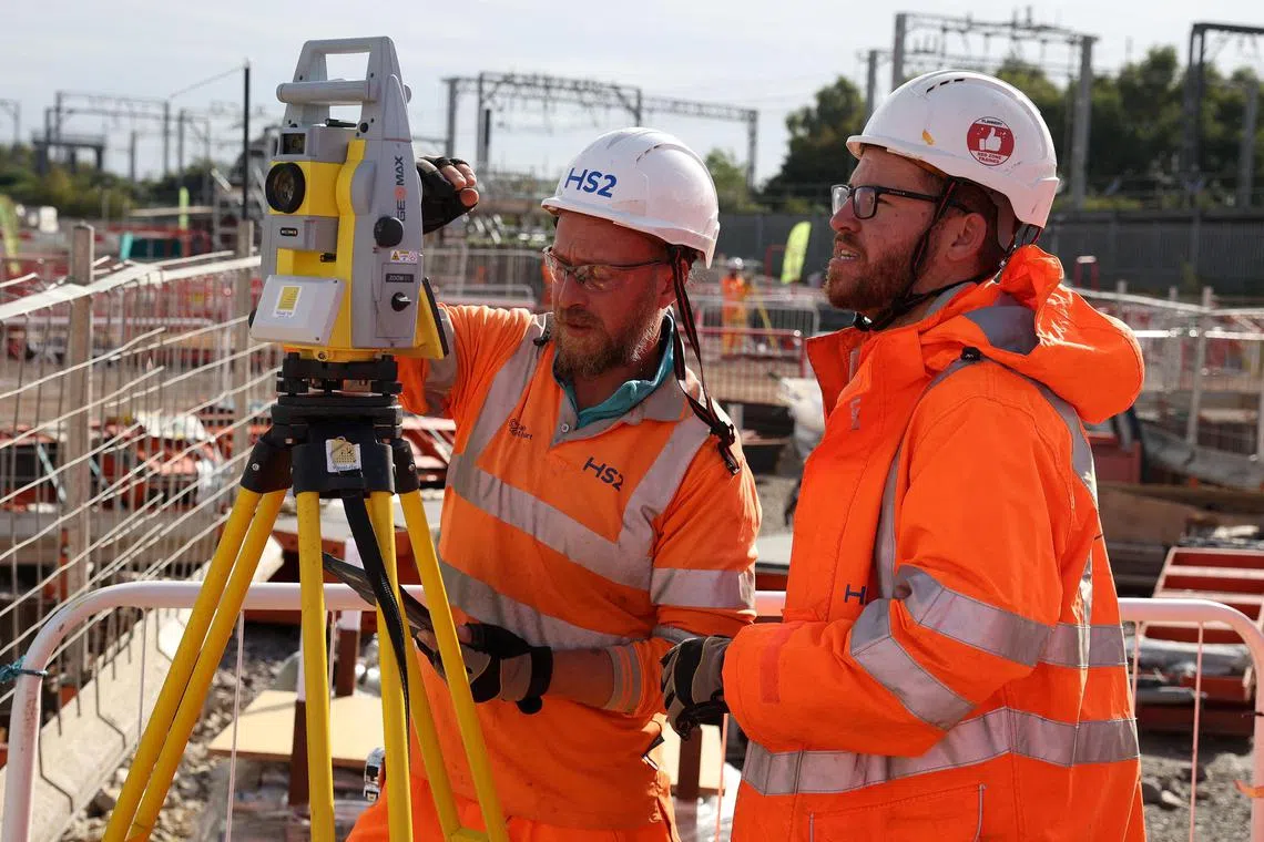 Workers operate a piece of measuring equipment at the HS2 rail Curzon Street Station construction site in Birmingham, Britain, October 3, 2022. The project’s estimated costs have almost tripled to more than £100 billion (S$173.6 billion) from £37.5 billion in 2013, making it one of the world’s most expensive lines.