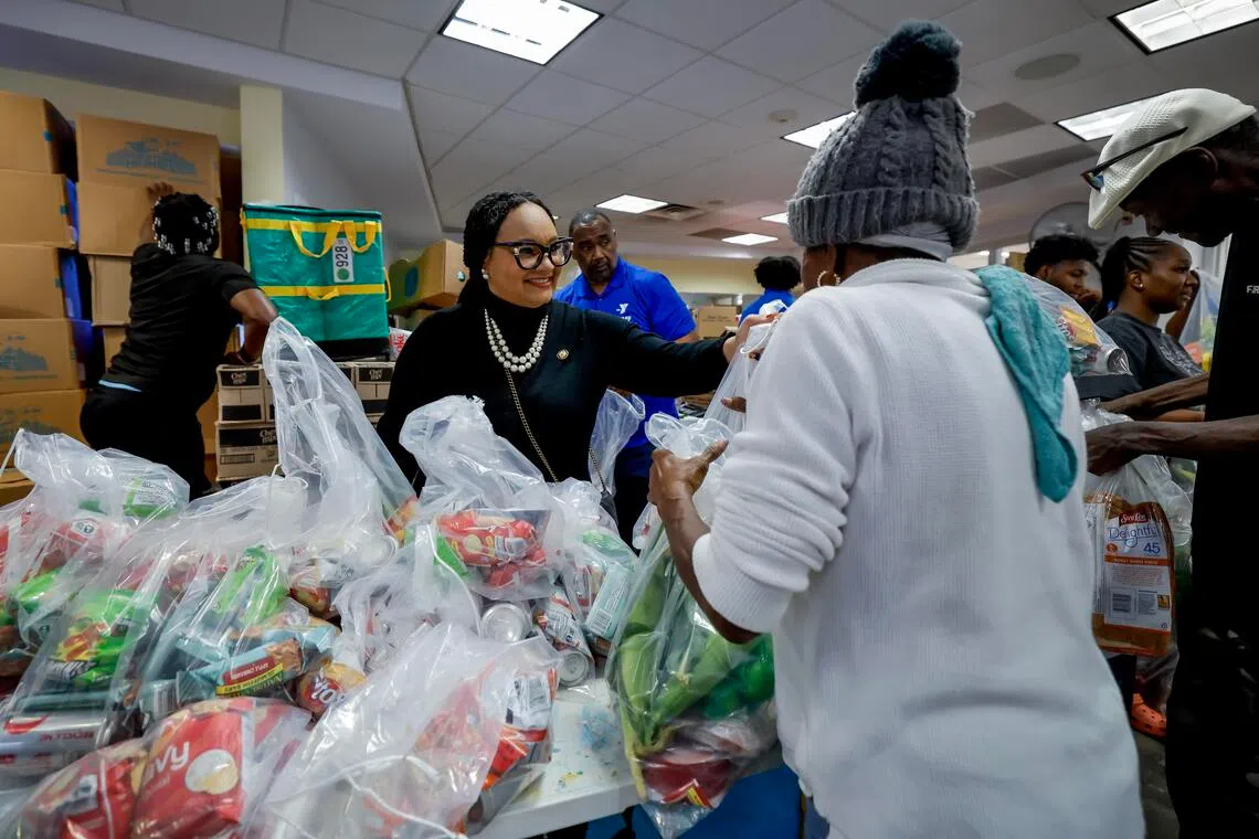 Democratic US Representative from Georgia Nikema Williams (left) helps distribute food aid bags during a free food distribution at the Young Family YMCA in Atlanta, Georgia, Nov 6, 2025. 