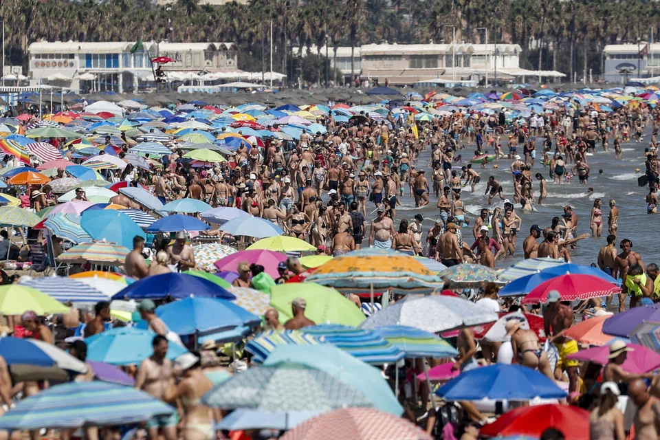 People crowd a beach during a hot day in Valencia, Spain, Aug 11, 2024. High temperatures, exceeding 40 deg C in some parts of Spain, are being recorded in a new heatwave, the fourth of the summer.  
