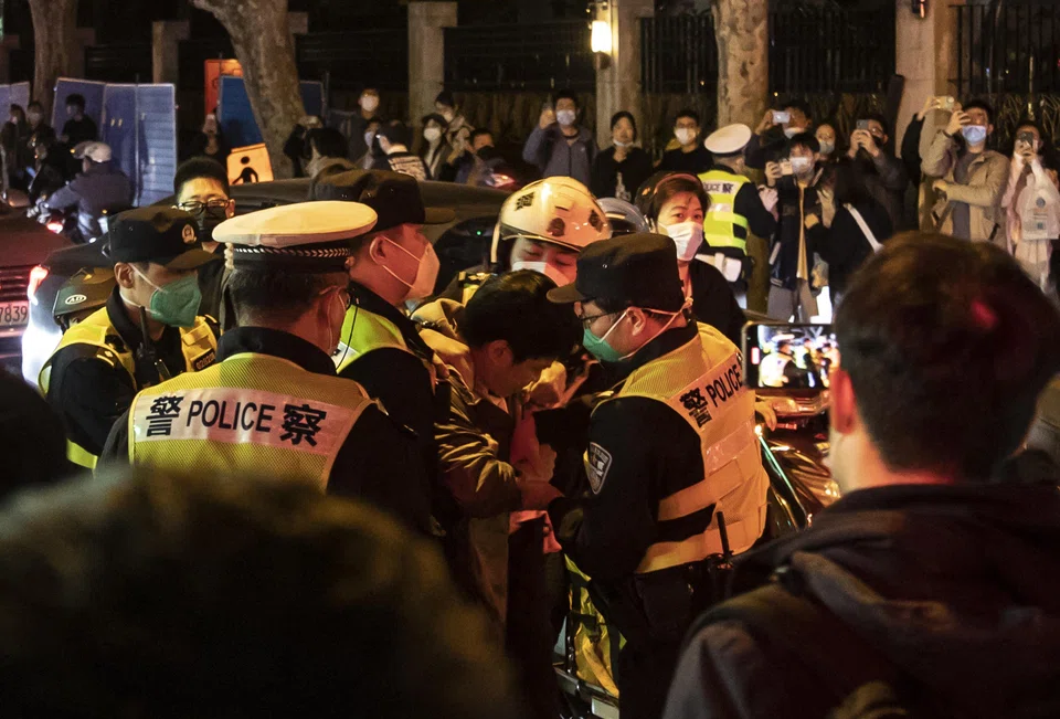 Police officers detain a man in Shanghai, China, on Nov 27, 2022. In a country where protests are swiftly quashed, many who gathered to voice their discontent over Covid-19 lock-down rules under the watchful eye of the police were uncertain about how far to go. 