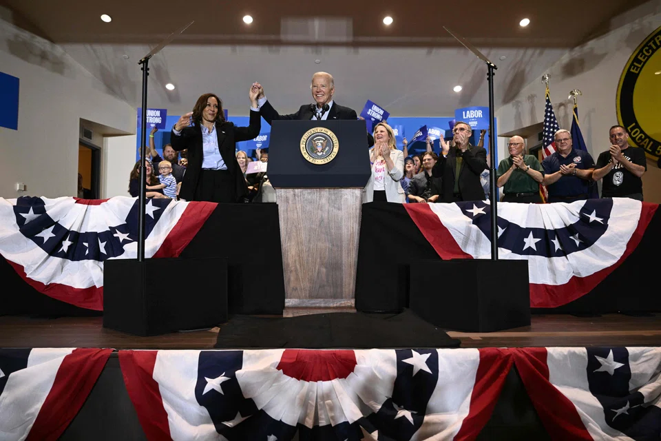 US President Joe Biden holds up US Vice-President and Democratic presidential candidate Kamala Harris's hand during a campaign rally at the International Brotherhood of Electrical Workers Local 5 in Pittsburgh, Pennsylvania, Sept 2, 2024. 