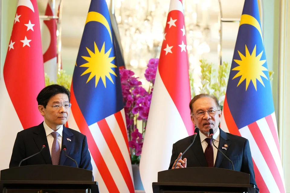 Prime Ministers Lawrence Wong (left) and Anwar Ibrahim speaking to reporters on Jan 7, 2025, during a press conference in Putrajaya.